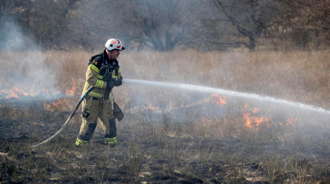 Brandman släcker gräsbrand